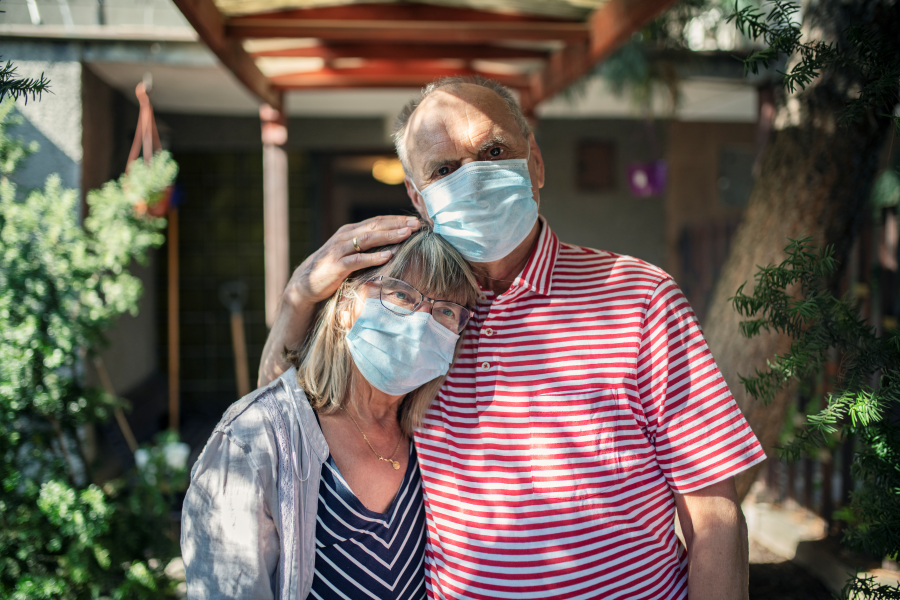 elderly couple hug with masks on