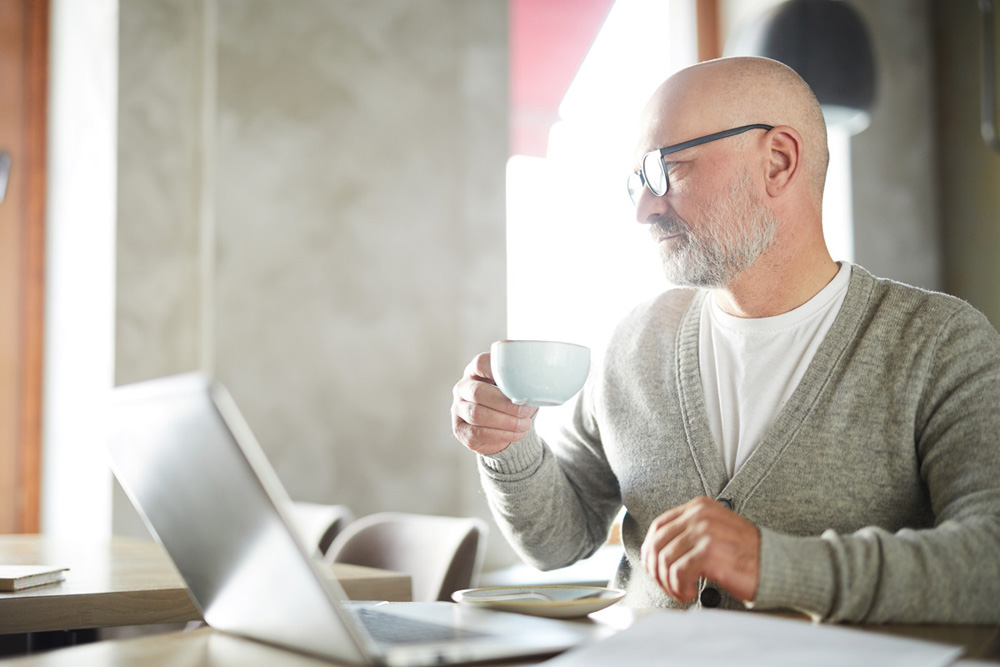 Introspective mature man at work in cafe