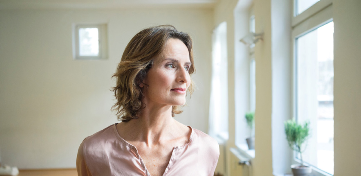 portrait of content woman looking out window